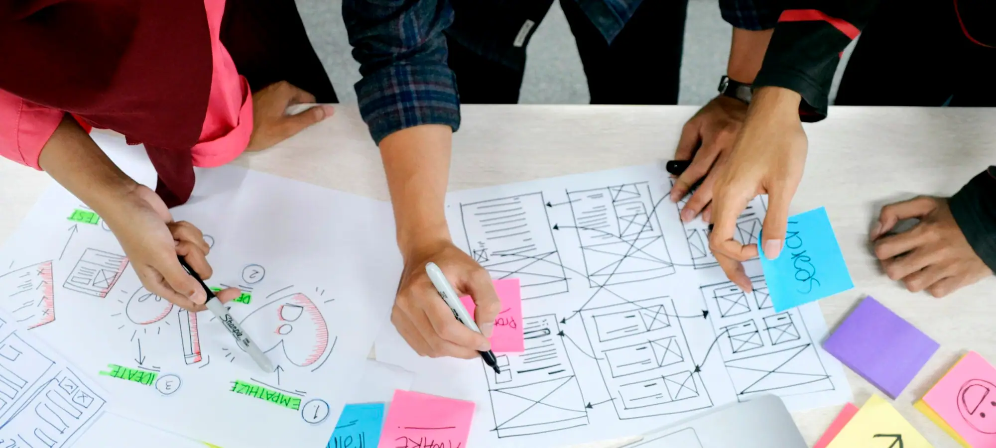 Marketing team sketching campaign ideas on paper