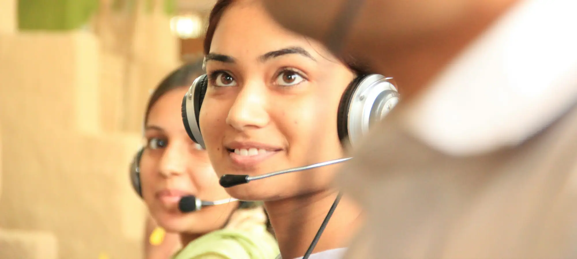 Customer service agents wearing headsets in a bright office