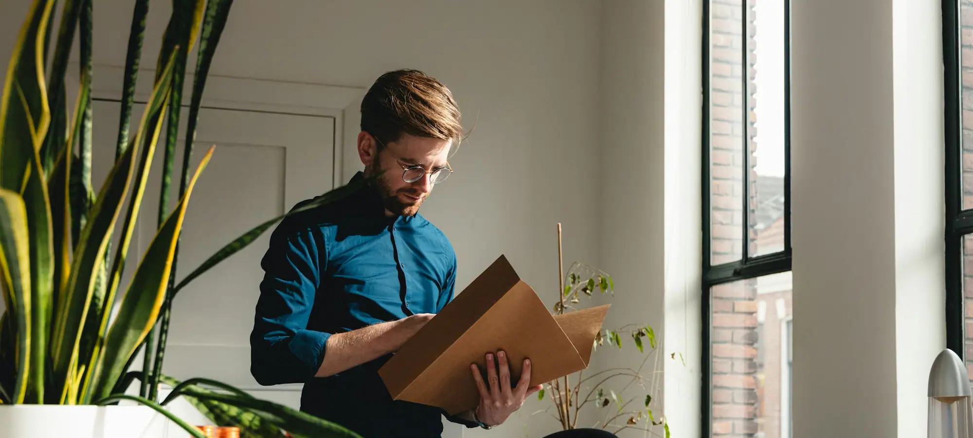 Man carrying a moving box through an office