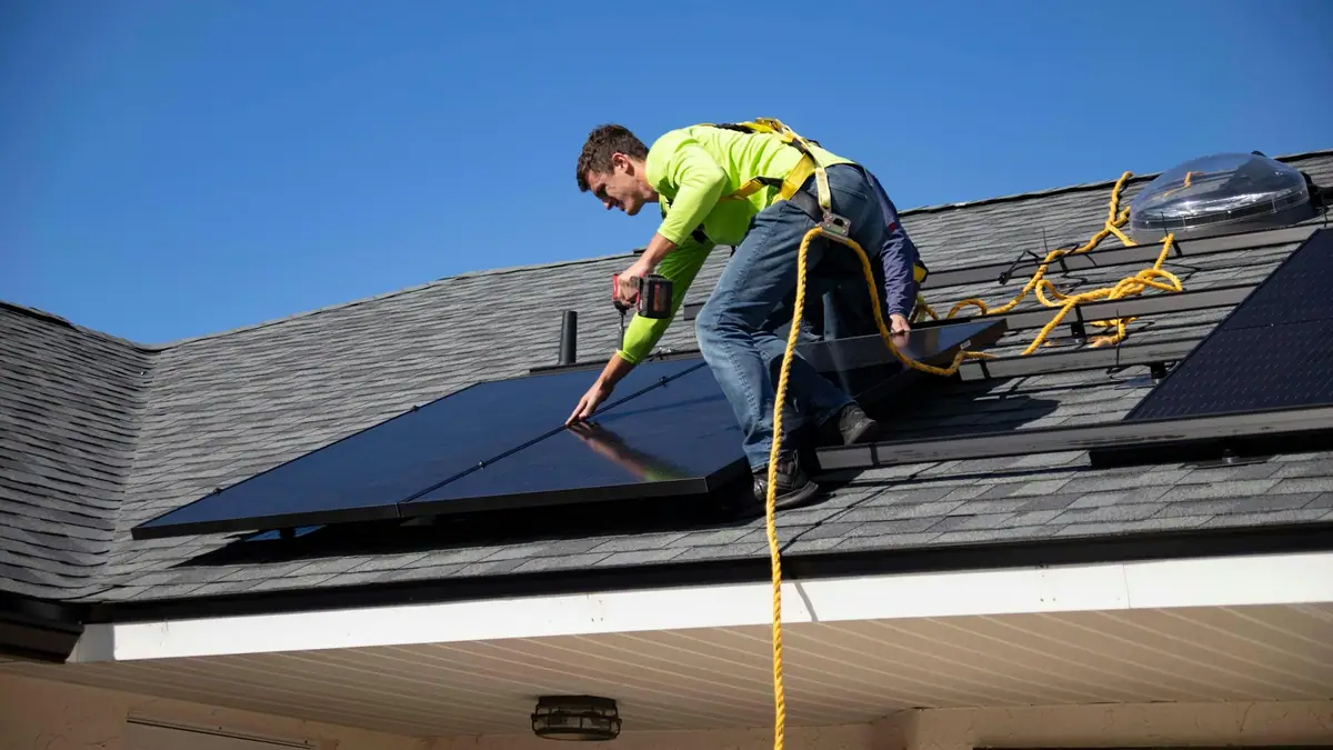 Installer fitting solar panels on a roof