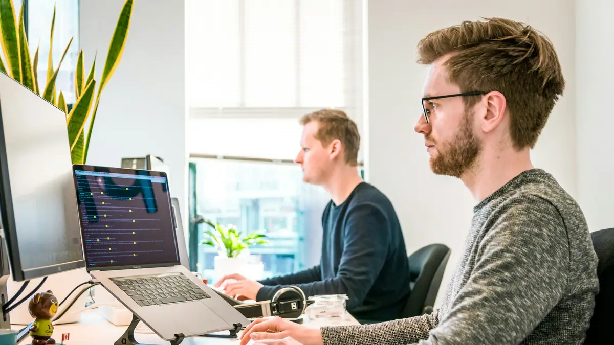 Software team working at desks with large monitors