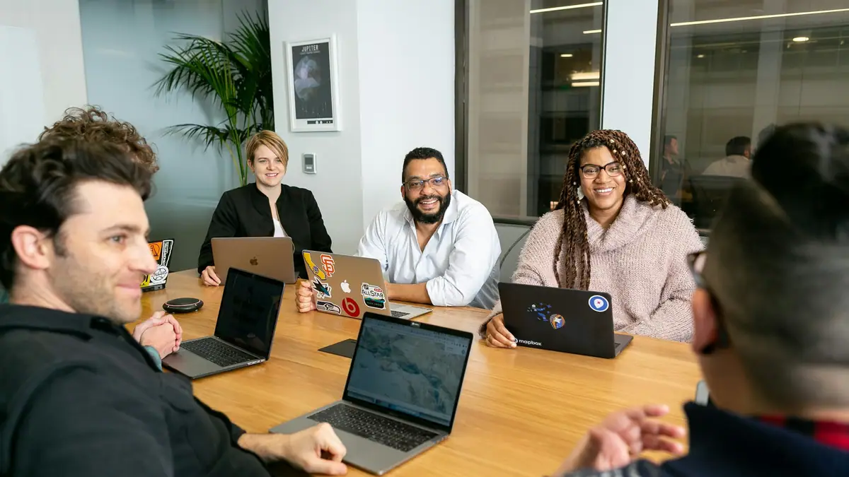 Technology services team meeting around laptops