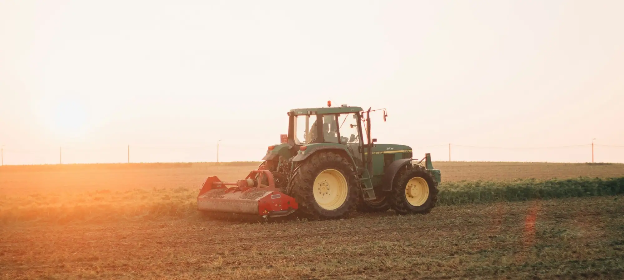Tractor working a field at sunset