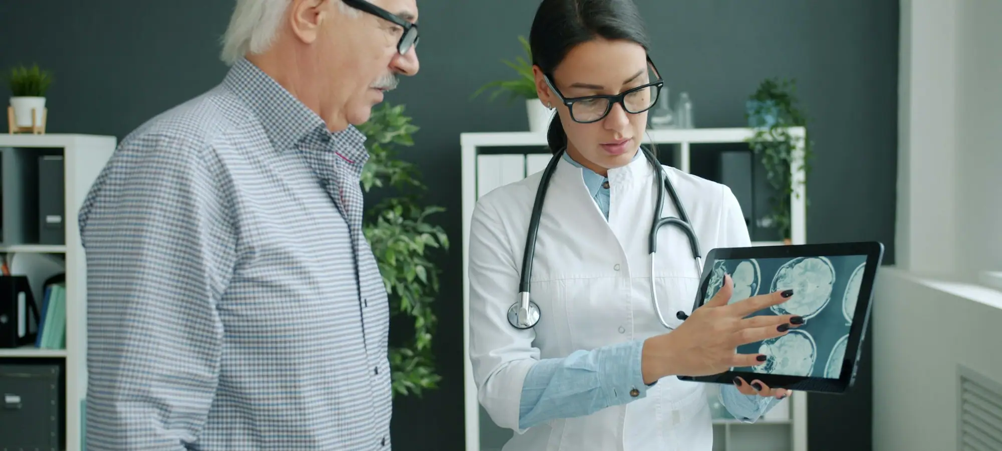 Doctor reviewing a scan on a tablet with a patient