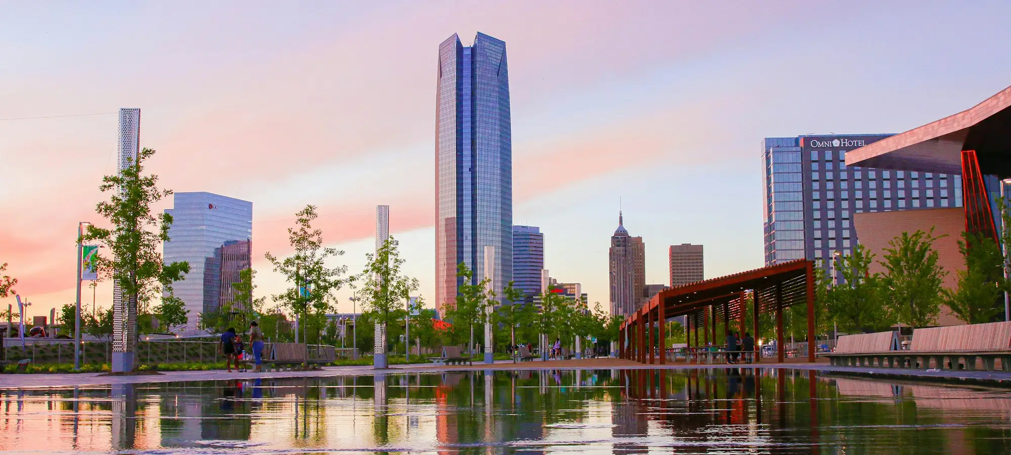 Downtown Oklahoma City towers reflected in water at sunset