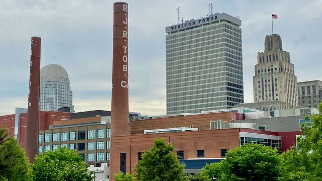 Downtown Winston-Salem skyline behind historic factory smokestacks