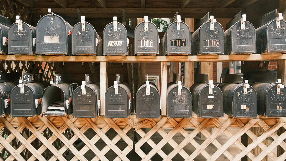 Rows of black mailboxes on wooden shelves