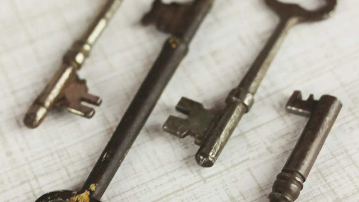 Four brass skeleton keys on a linen surface