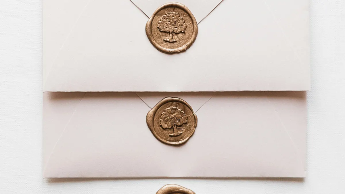 White envelopes closed with gold wax seals