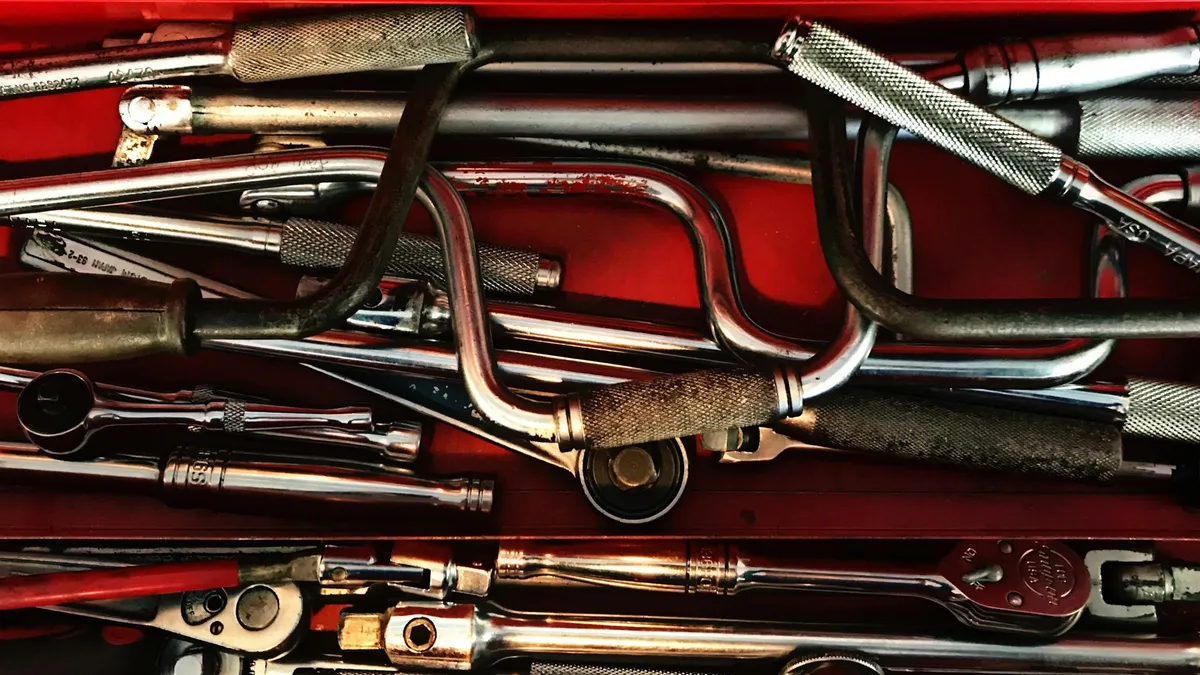 Hand tools piled in a red toolbox drawer
