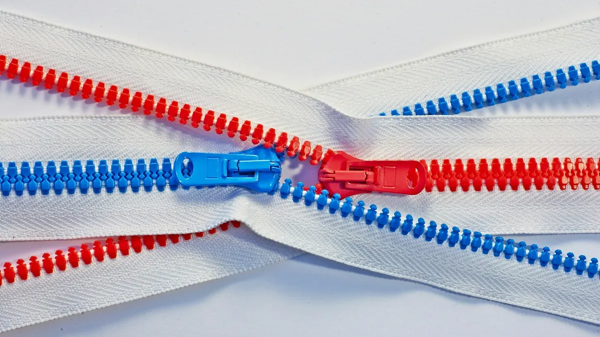 Red and blue zippers crossing on a white background