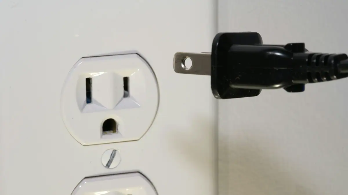 Plug about to connect to a wall socket