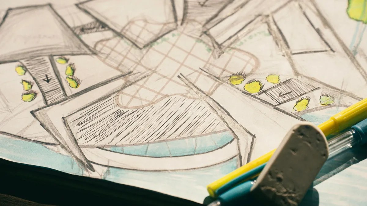 Pencil sketch of a building floor plan with markers and an eraser