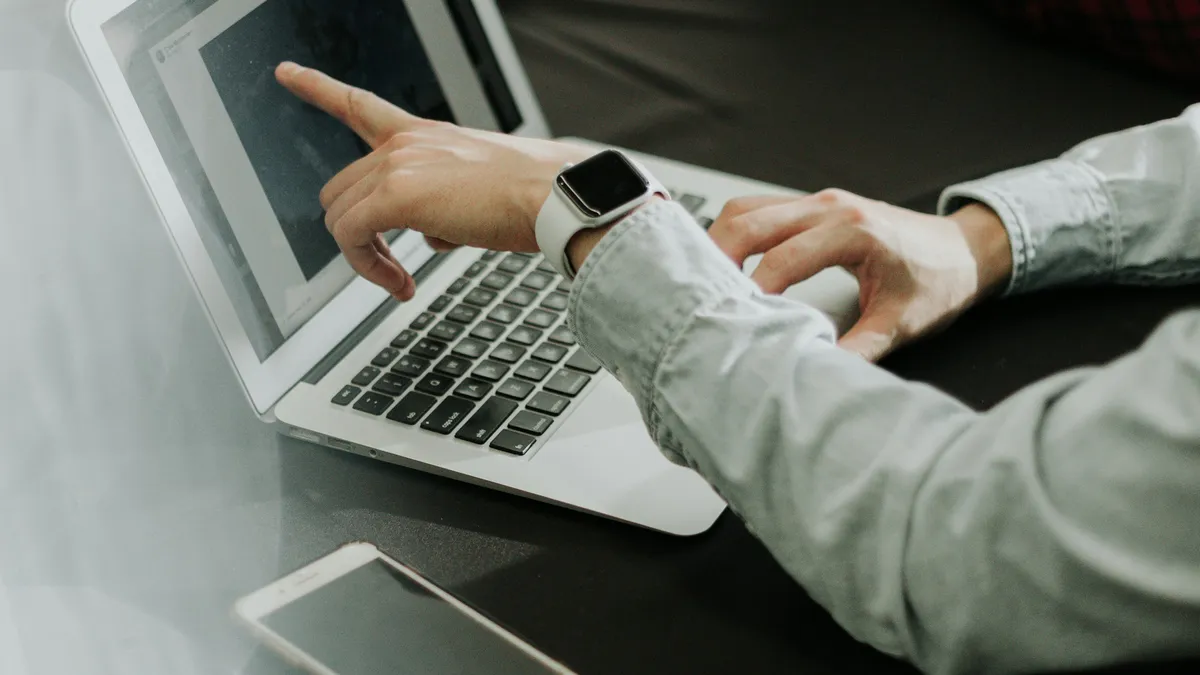 Two people reviewing a sales pipeline on a laptop