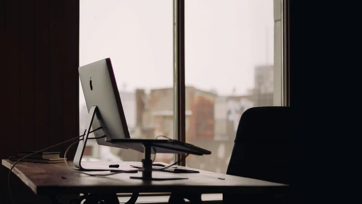 Empty desk and chair by an office window