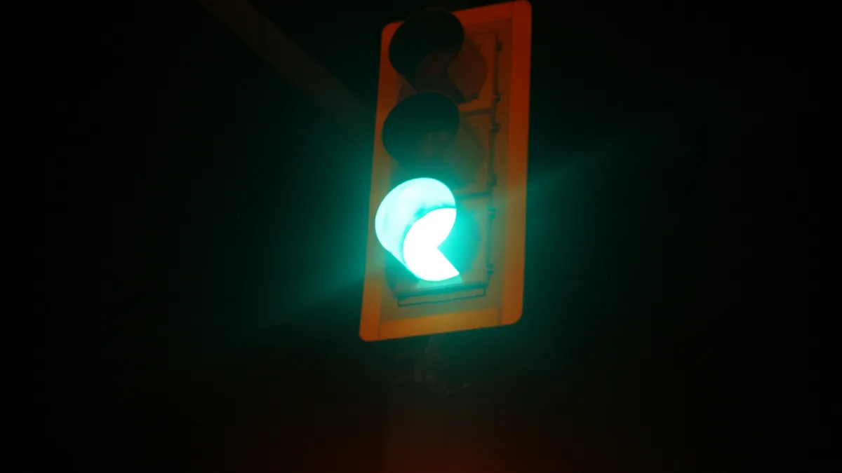 Green traffic signal glowing against a dark sky