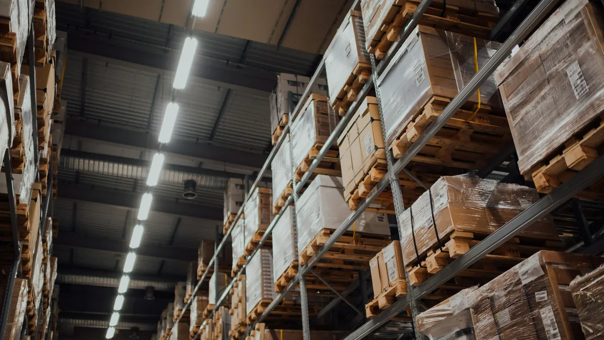 Tall warehouse racks stacked with cartons on pallets