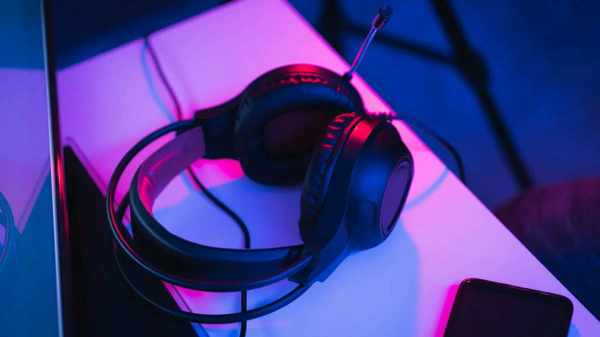 Headset resting on a desk under colored light