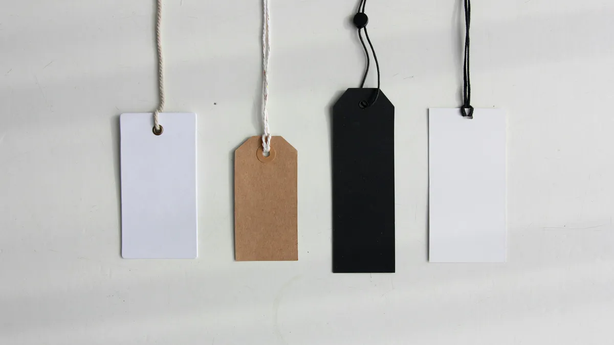 Four blank price tags hanging on strings