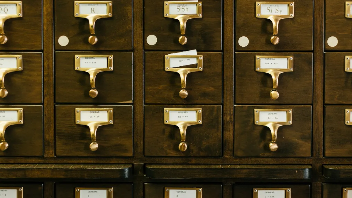 Wooden card catalog drawers with labeled brass pulls