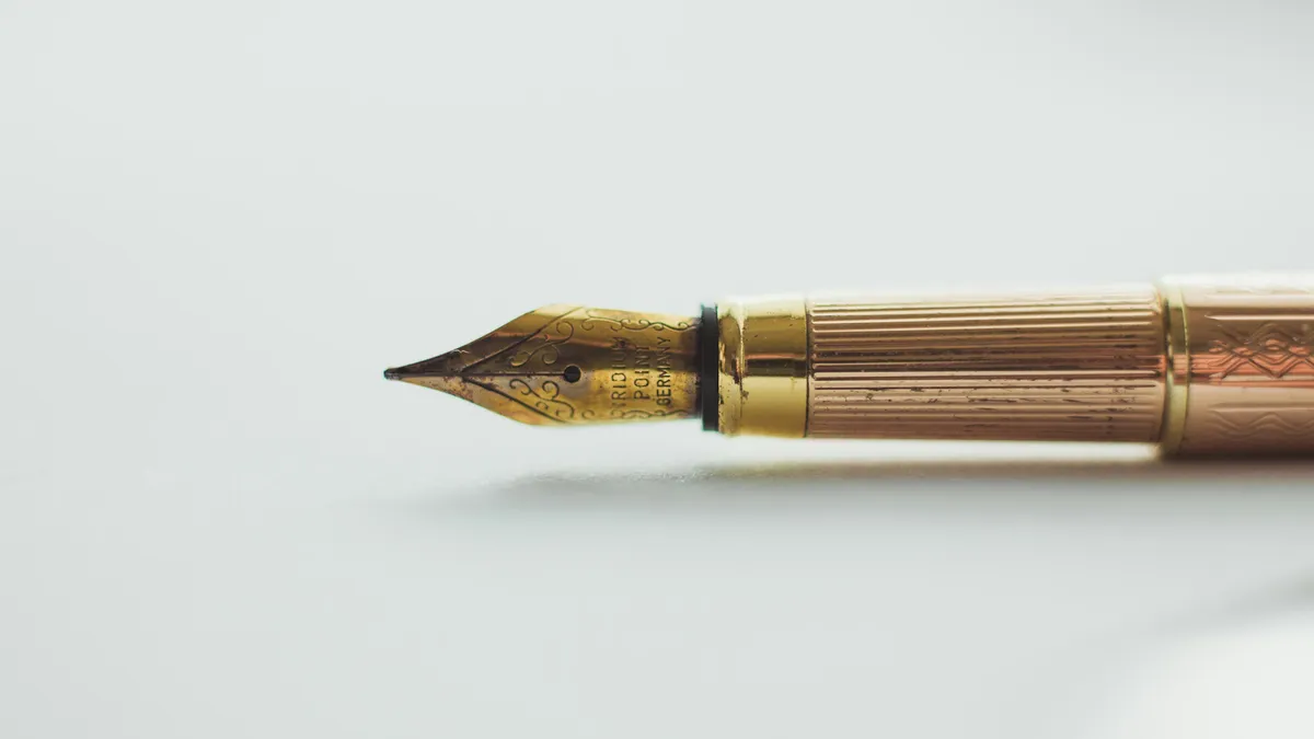 Gold fountain pen nib on a white surface