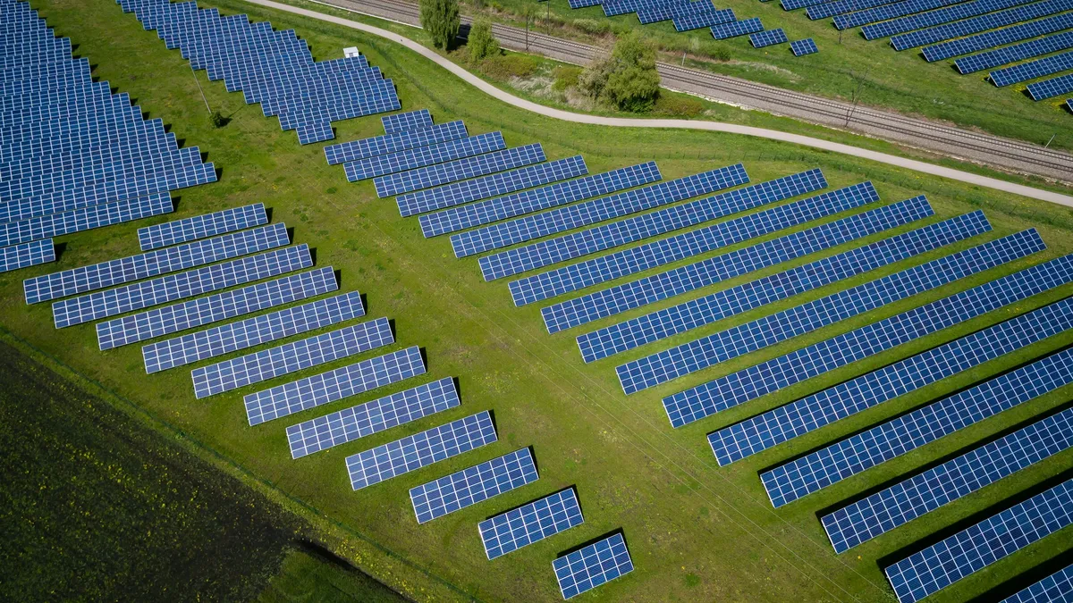 Aerial view of rows of solar panels on a green field