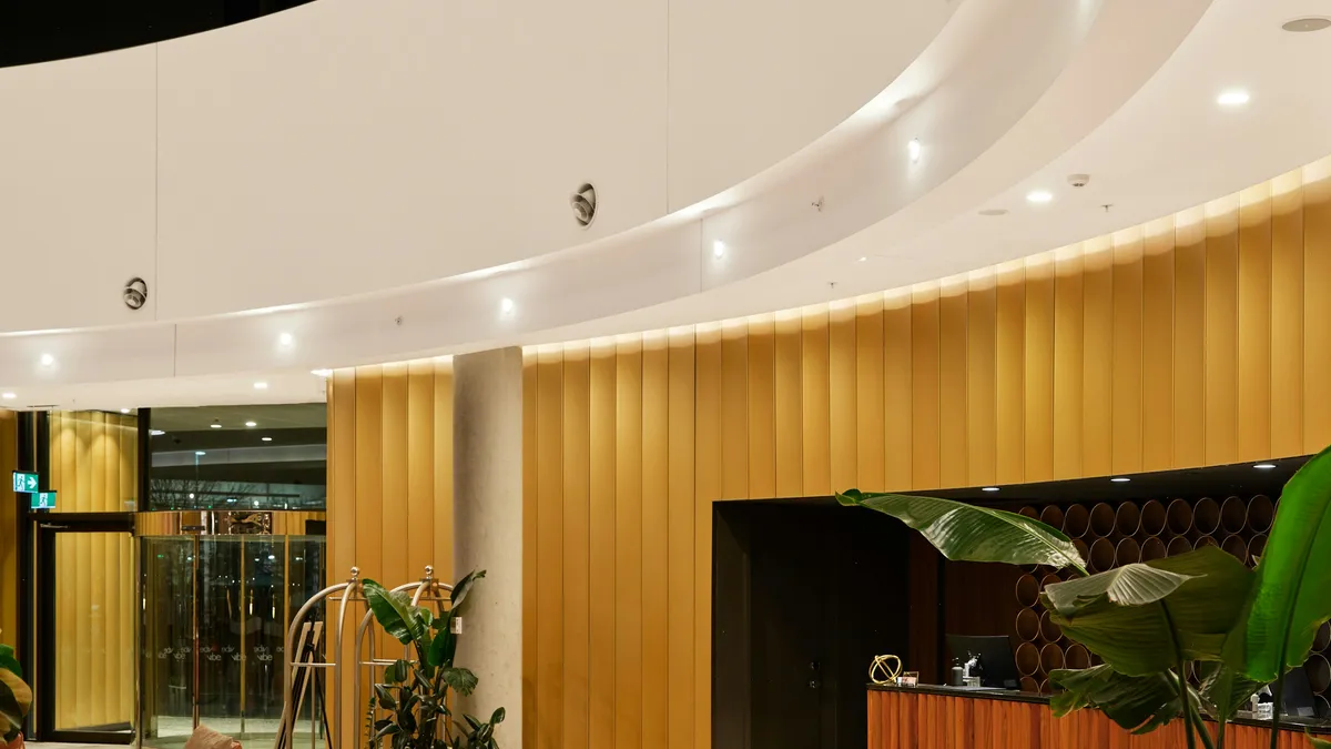 Modern hotel lobby with a reception desk and plants