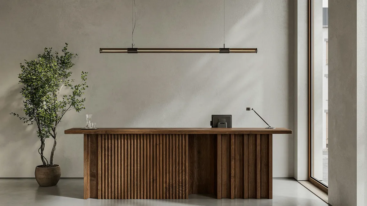 Minimal reception desk with a potted tree in a bright lobby