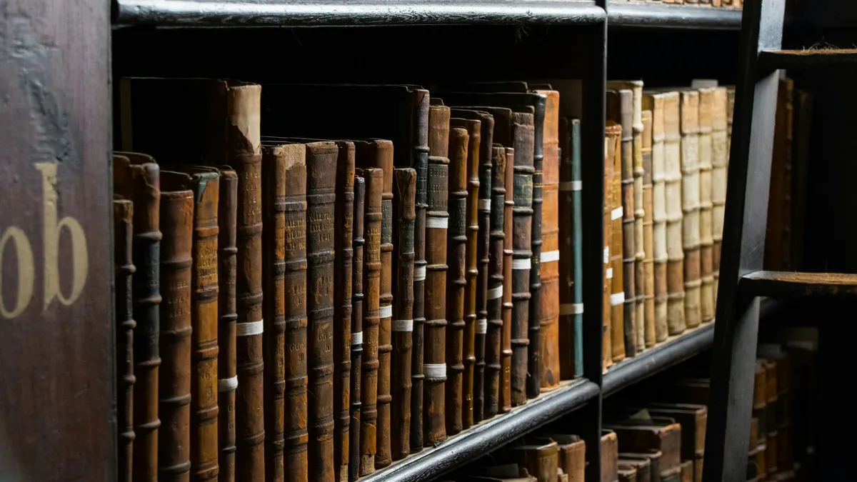 Library bookshelves lined with old bound volumes