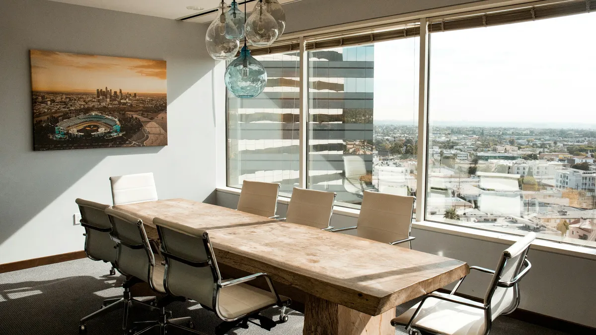 Empty conference room with a long table and city view