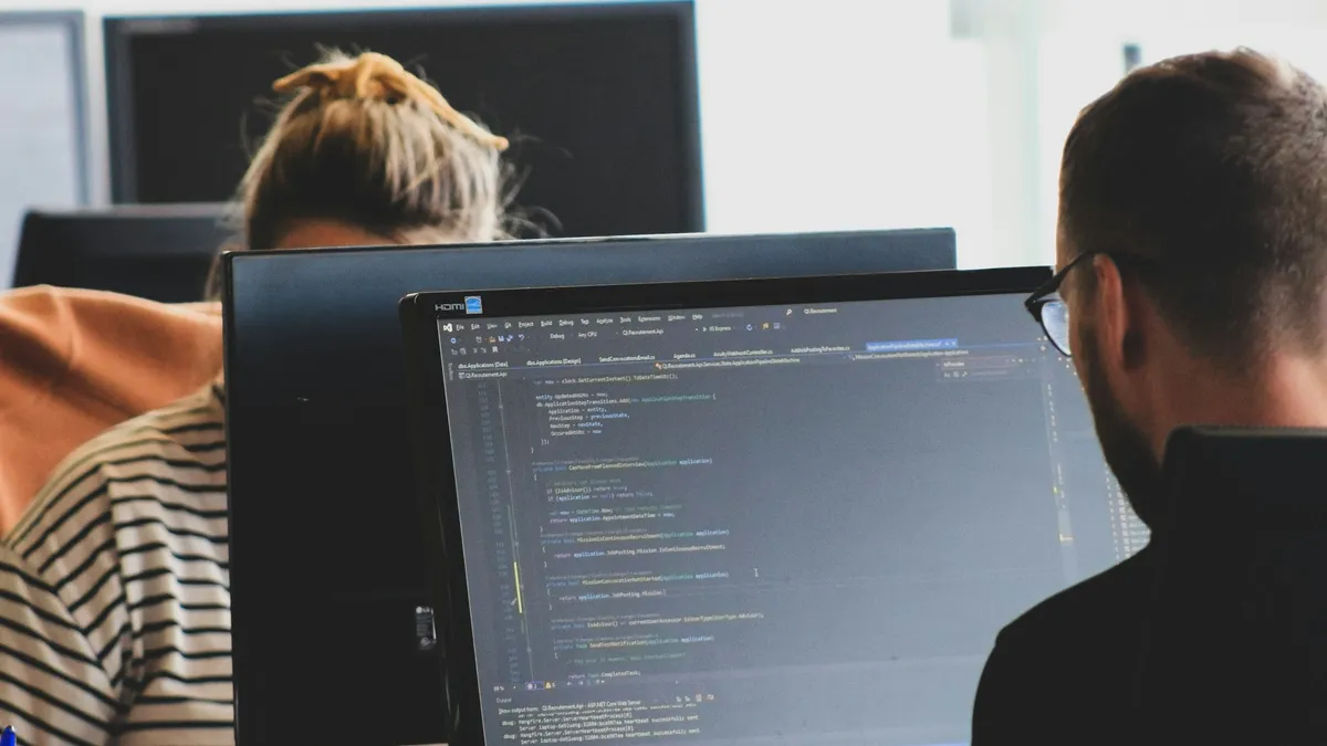 Software team working on code at monitors