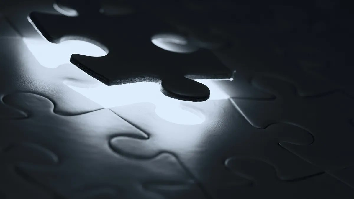 A dark puzzle piece hovering above its matching empty slot