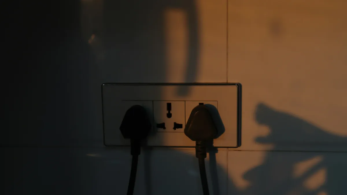 Two plugs in a wall socket lit by warm evening light
