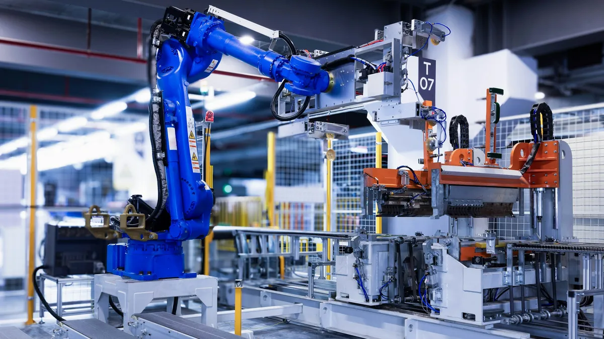 Blue industrial robot arm on a factory assembly line