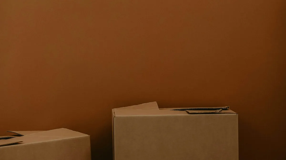 Stack of brown cardboard boxes against a brown wall