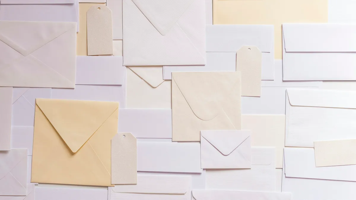 Assorted paper envelopes laid out on a wall