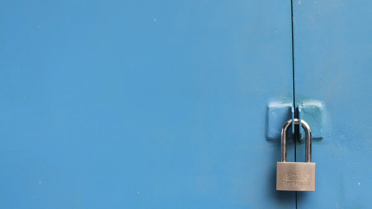 Padlock securing a blue metal door