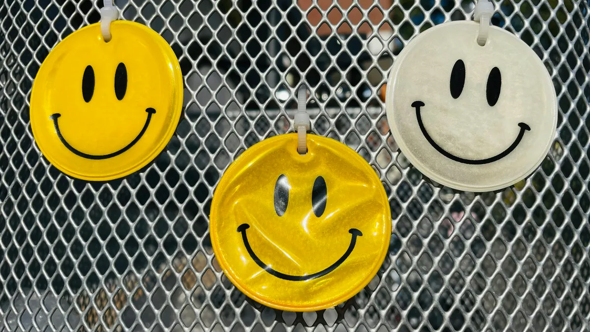 Smiley-face reflectors hanging on a wire fence