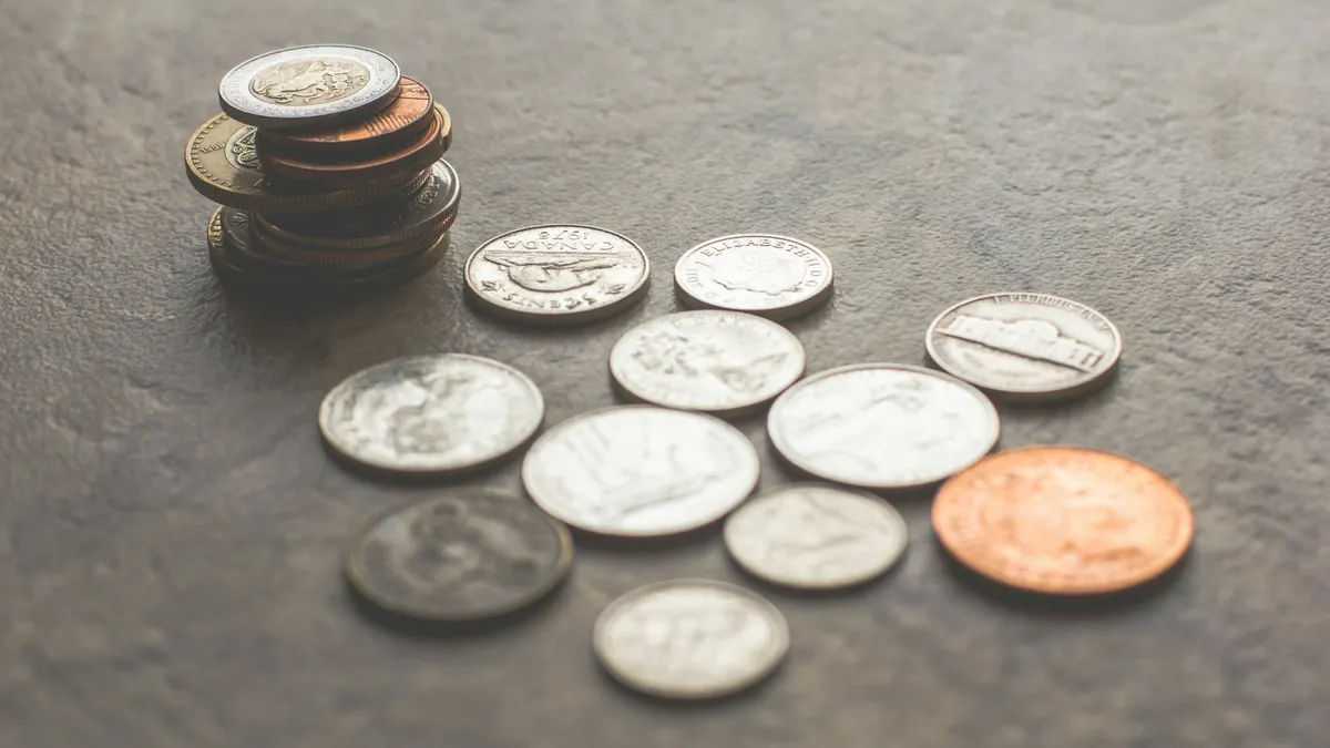 Coins stacked and scattered on a gray surface