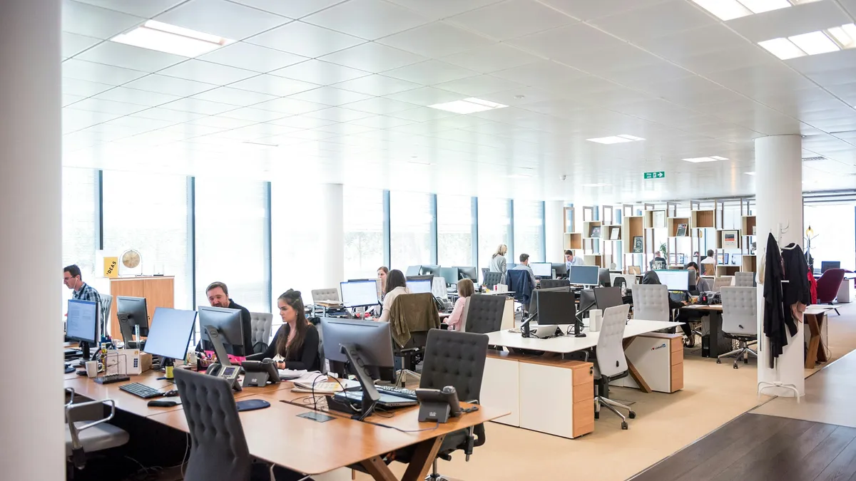 Open-plan office with teams working at desks and phones