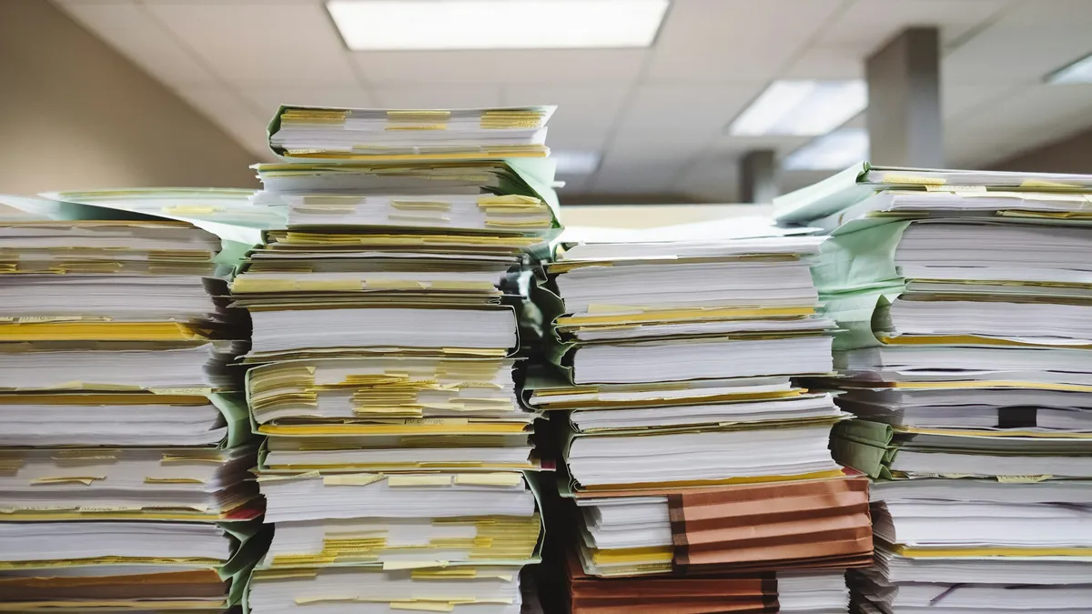 Tall stacks of paper files and folders in an office