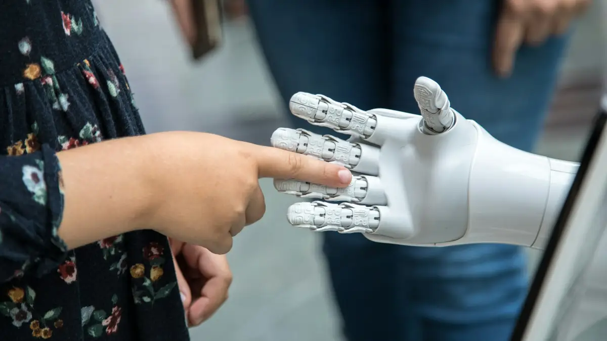 Human hand reaching toward a robotic hand
