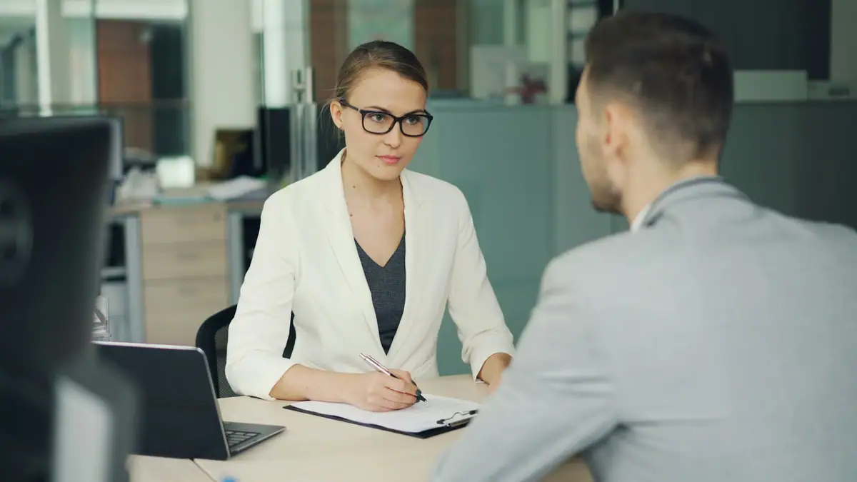 Interviewer meeting a candidate across a desk