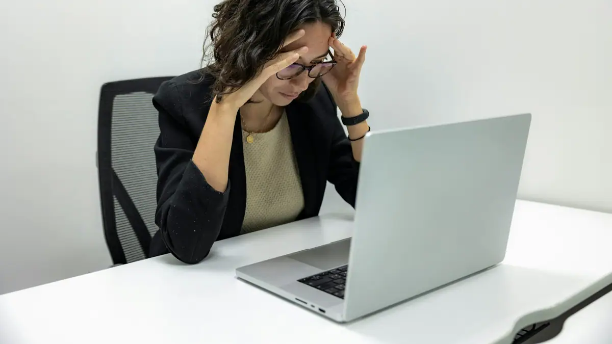 Frustrated employee looking at a laptop